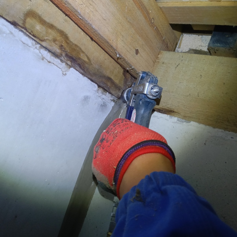 床下の木材にシロアリ駆除剤を注入する様子