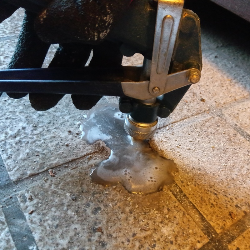 玄関の床にシロアリ駆除剤を注入する様子