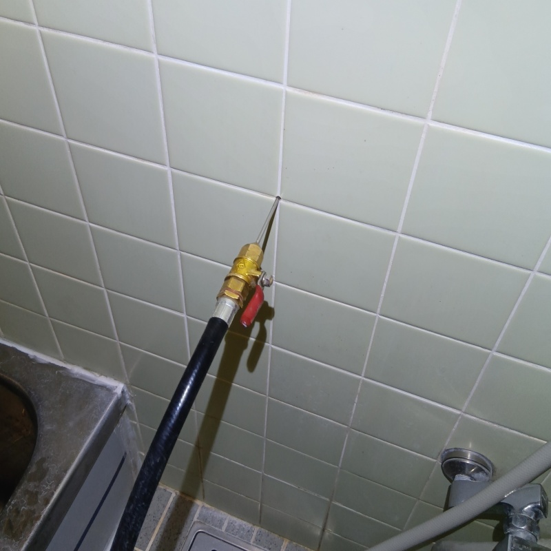 浴室の壁にシロアリ駆除剤を注入する様子