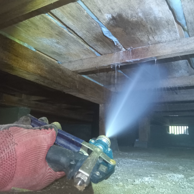 床下の木材にシロアリ駆除剤を散布する様子