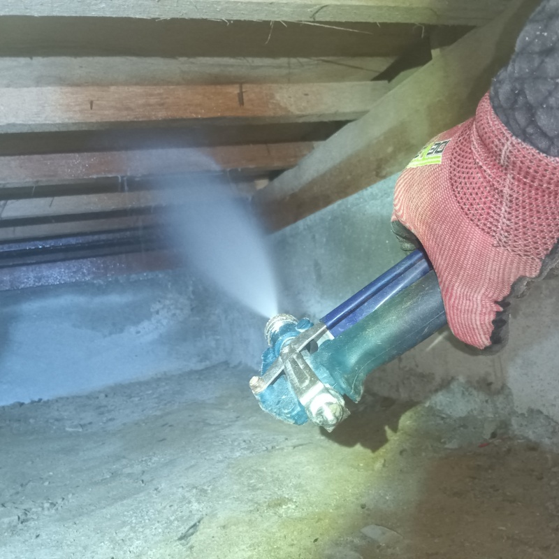 床下の木材にシロアリ駆除剤を散布する様子