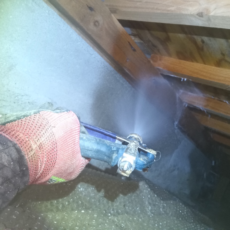 床下の基礎部分にシロアリ駆除剤を散布する様子