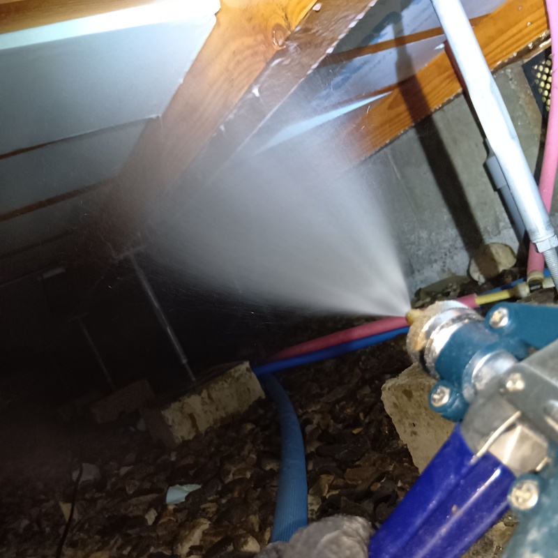 床下の木材にシロアリ駆除剤を散布する様子