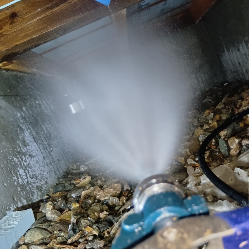 床下の土壌にシロアリ駆除剤を散布する様子