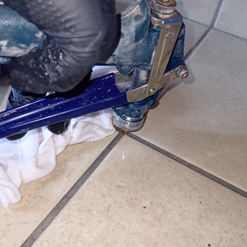 浴室の床にシロアリ駆除剤を注入する様子