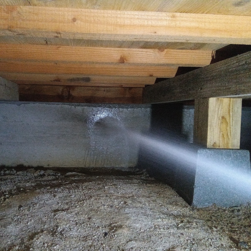 床下の基礎部分にシロアリ駆除剤を散布する様子