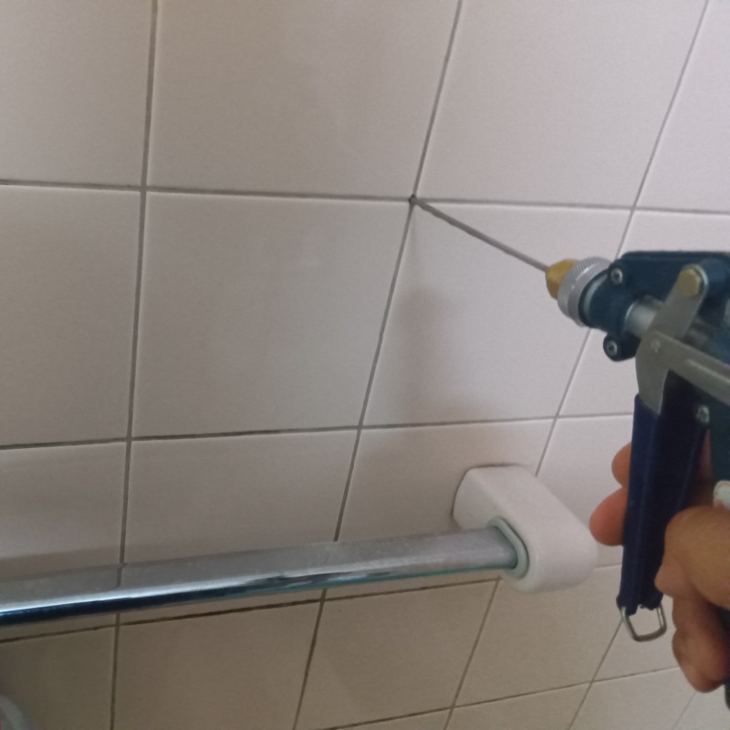 浴室の床にシロアリ駆除剤を注入する様子