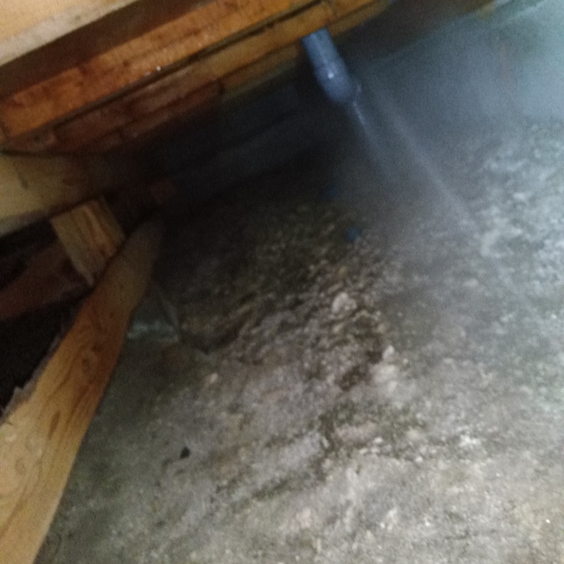 床下の土壌にシロアリ駆除剤を散布する様子