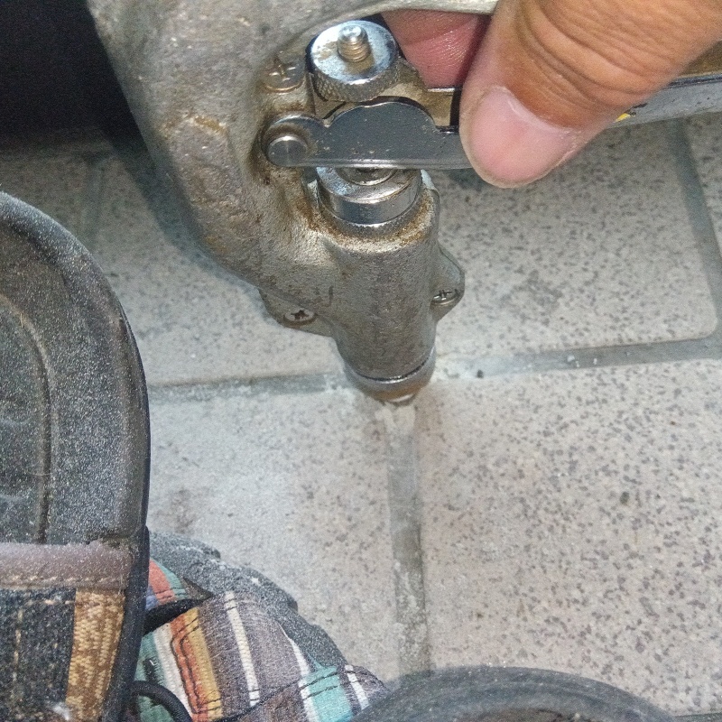 玄関の床にシロアリ駆除剤を注入する様子