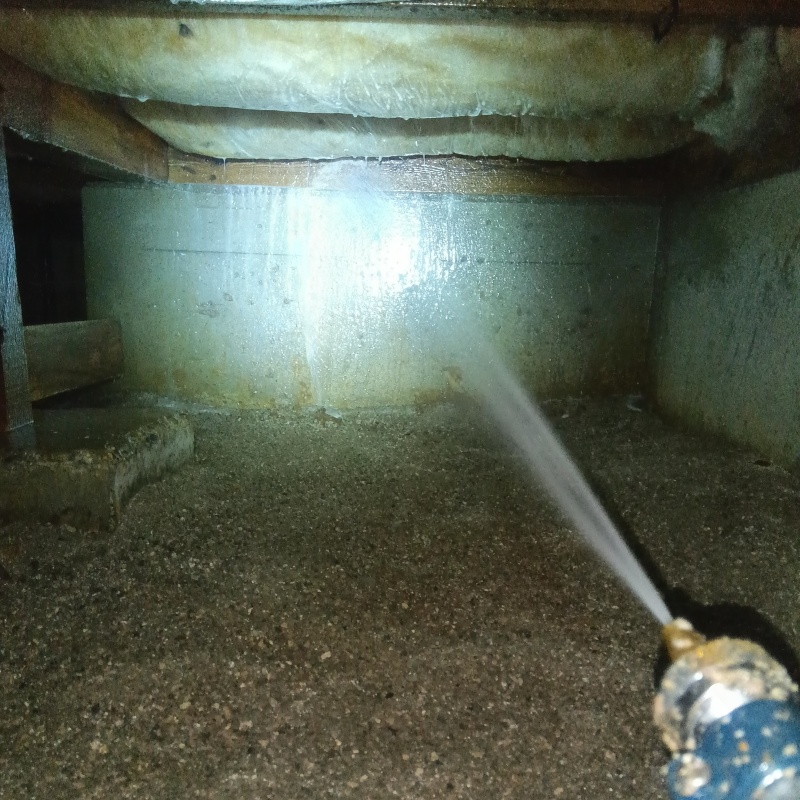 床下の基礎部分にシロアリ駆除剤を散布する様子