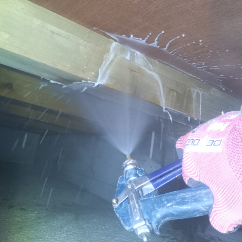 床下の木材にシロアリ駆除剤を散布する様子