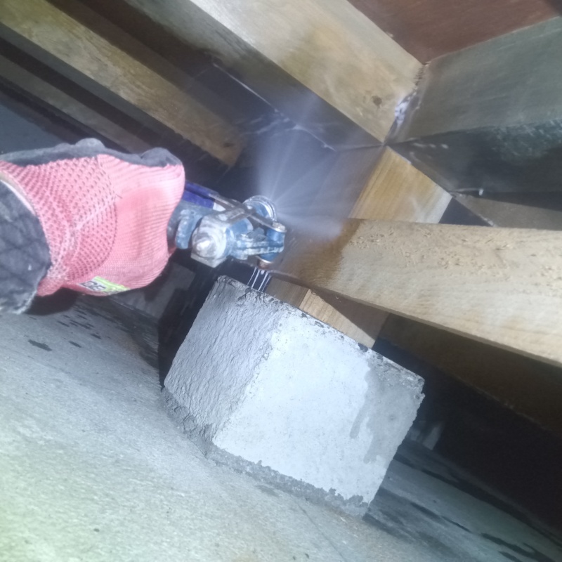 床下の木材にシロアリ駆除剤を散布する様子