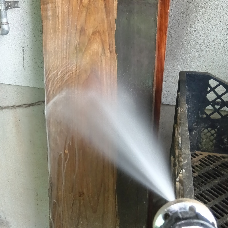 玄関近くの柱にシロアリ駆除剤を散布する様子