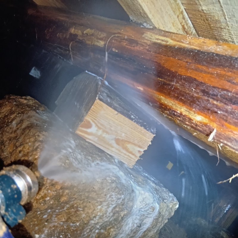 床下の木材にシロアリ駆除剤を散布する様子