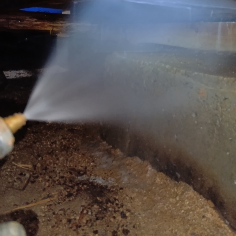 床下の基礎部分にシロアリ駆除剤を散布する様子