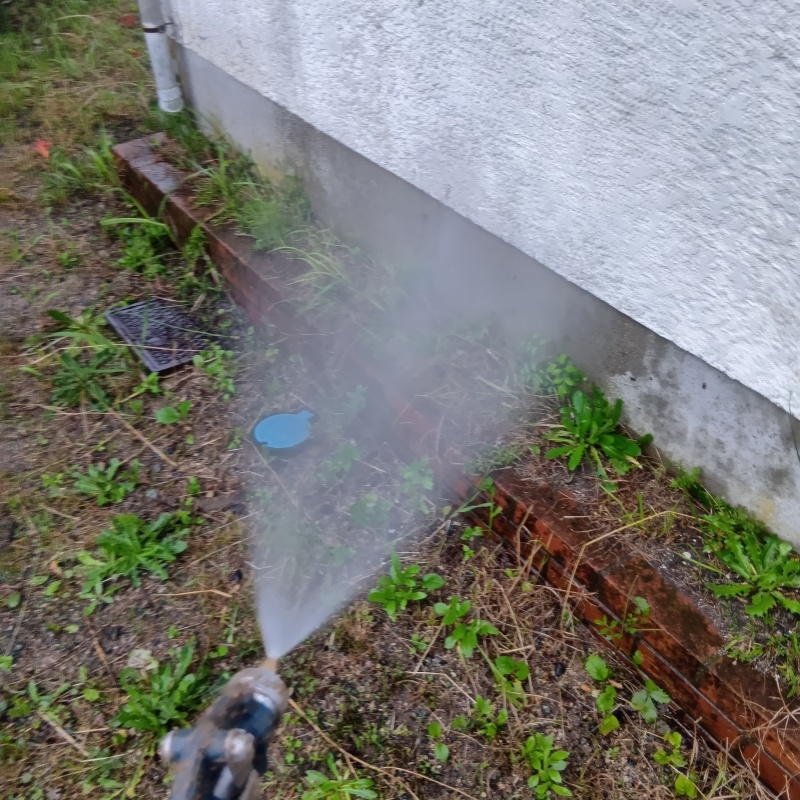 基礎まわりにシロアリ駆除剤を散布する様子