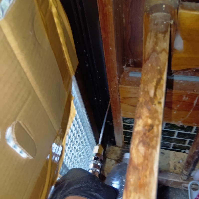 玄関の縦枠にシロアリ駆除剤を注入する様子