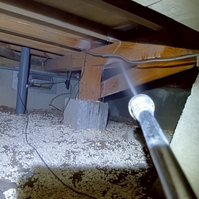 床下の木材にシロアリ駆除剤を散布する様子