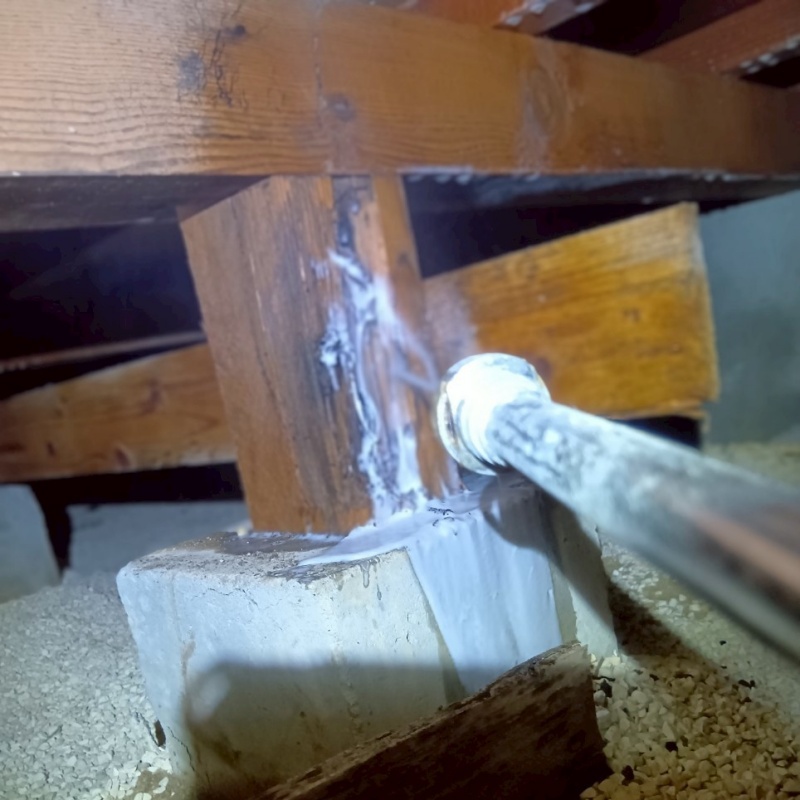床下の木材にシロアリ駆除剤を散布する様子