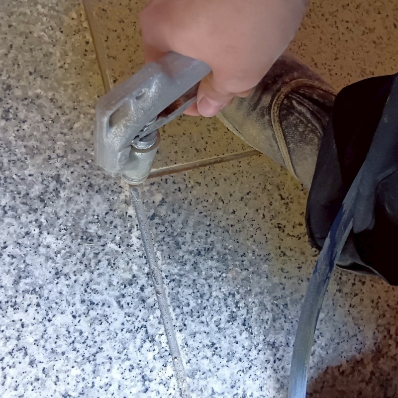 玄関の床にシロアリ駆除剤を注入する様子