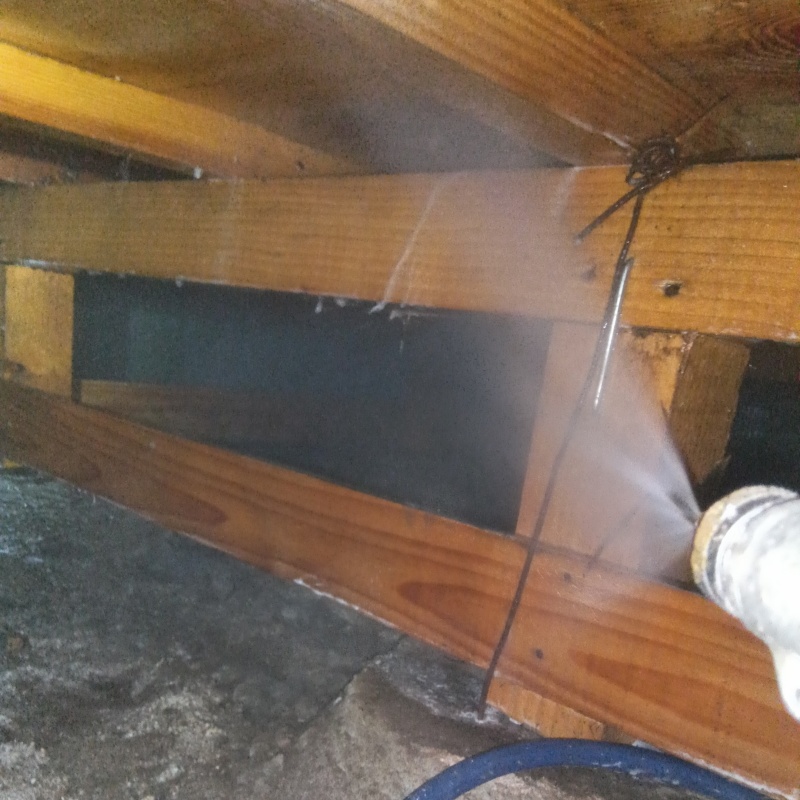 床下の木材にシロアリ駆除剤を散布する様子