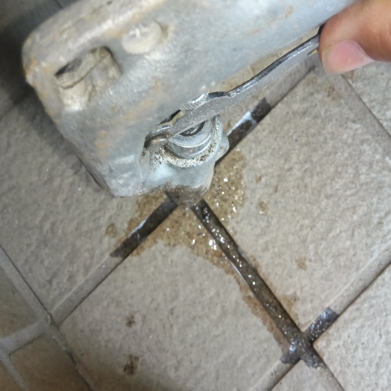 玄関の床にシロアリ駆除剤を注入する様子