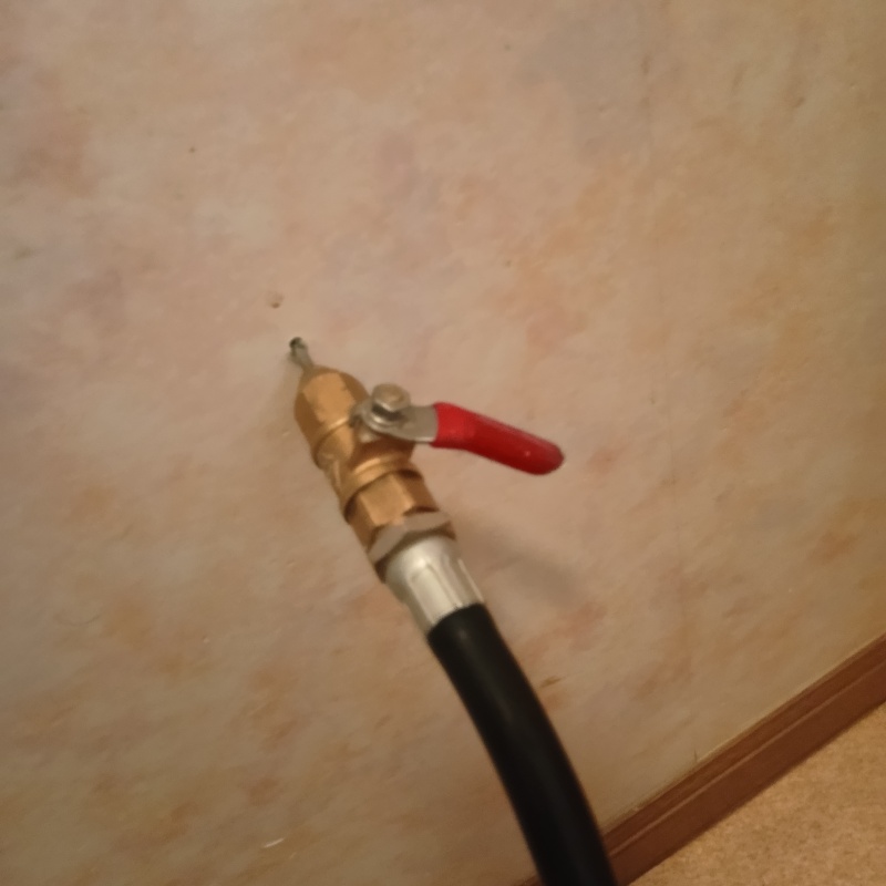 洗面所の壁にシロアリ駆除剤を注入する様子