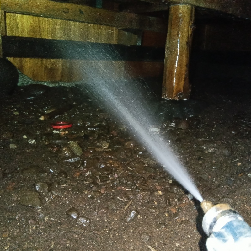 床下の木材にシロアリ駆除剤を散布する様子