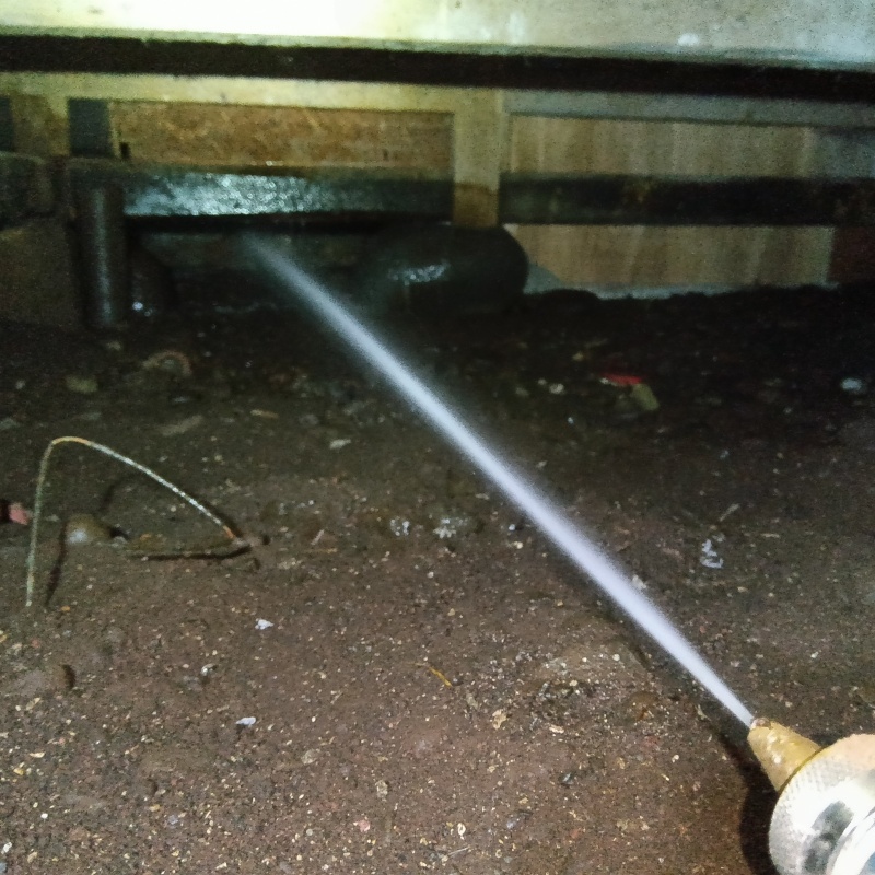 床下の木材にシロアリ駆除剤を散布する様子