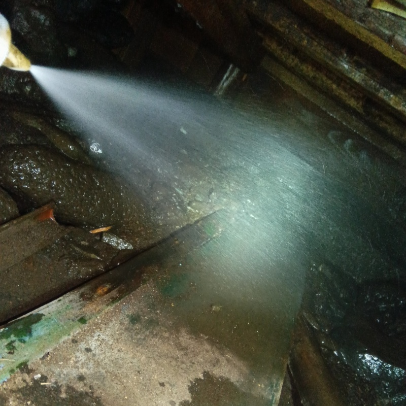 床下の土壌にシロアリ駆除剤を散布する様子