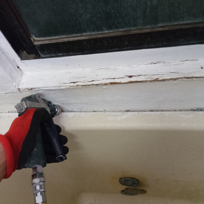 浴室の壁にシロアリ駆除剤を注入する様子