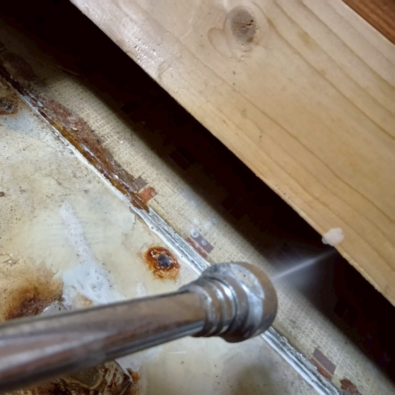 床下の土壌にシロアリ駆除剤を散布する様子