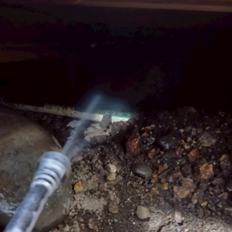 床下の土壌にシロアリ駆除剤を散布する様子