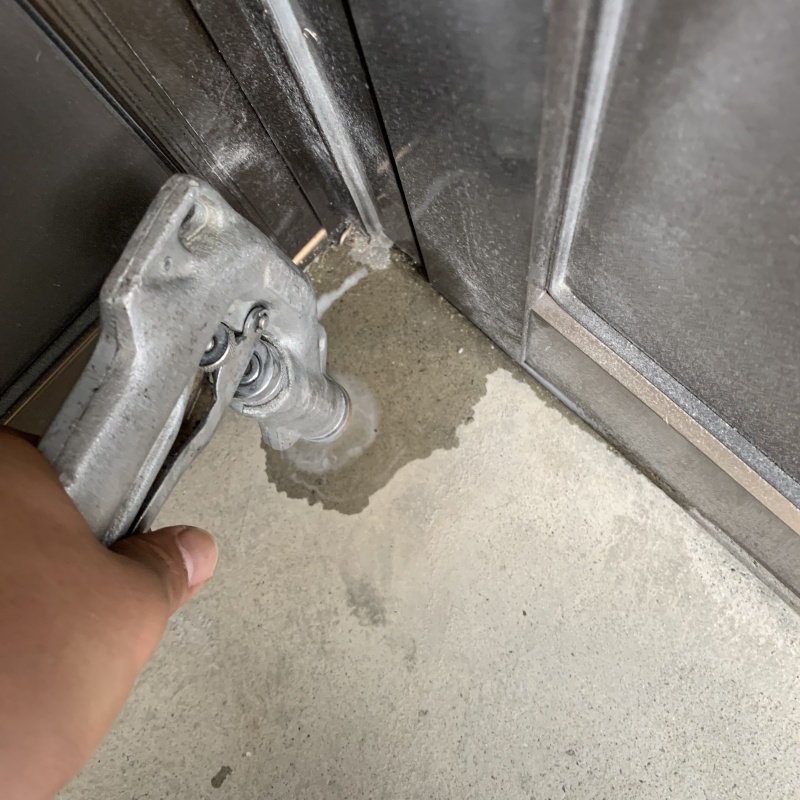 玄関の床にシロアリ駆除剤を注入する様子