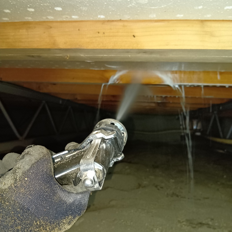 床下の木材にシロアリ駆除剤を散布する様子