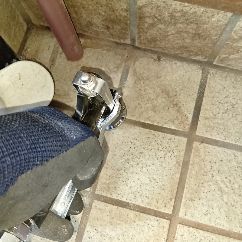 玄関の床にシロアリ駆除剤を注入する様子