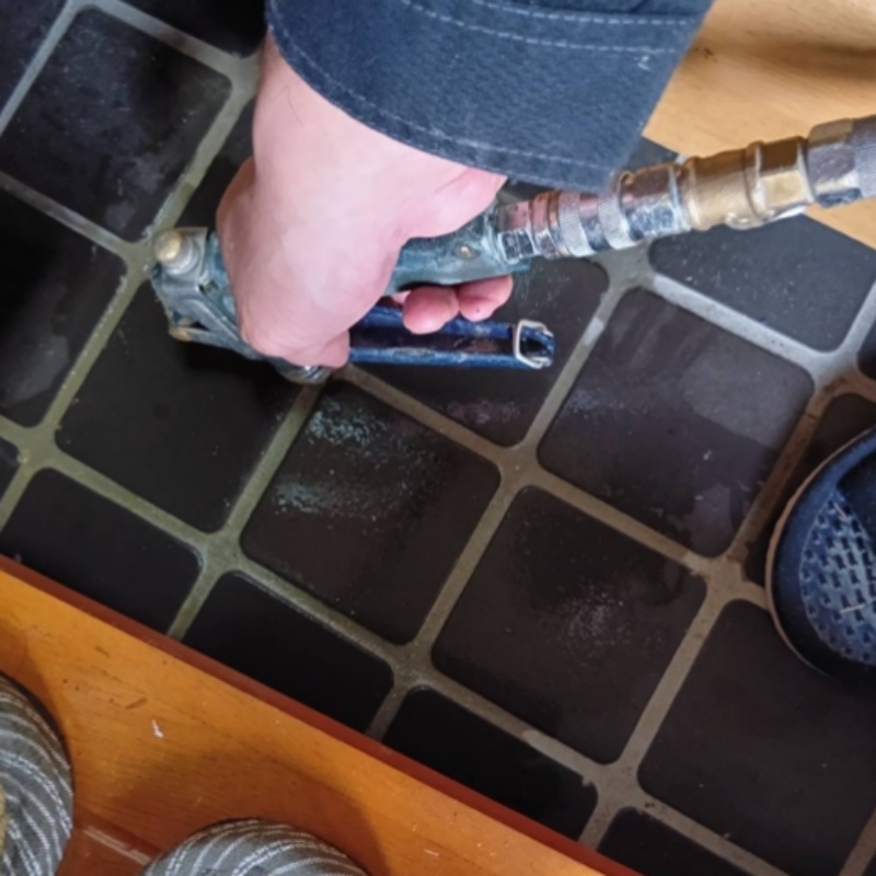 玄関の床にシロアリ駆除剤を注入する様子