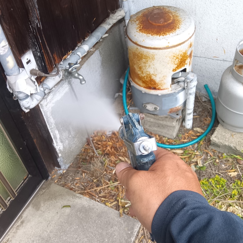 基礎まわりにシロアリ駆除剤を散布する様子