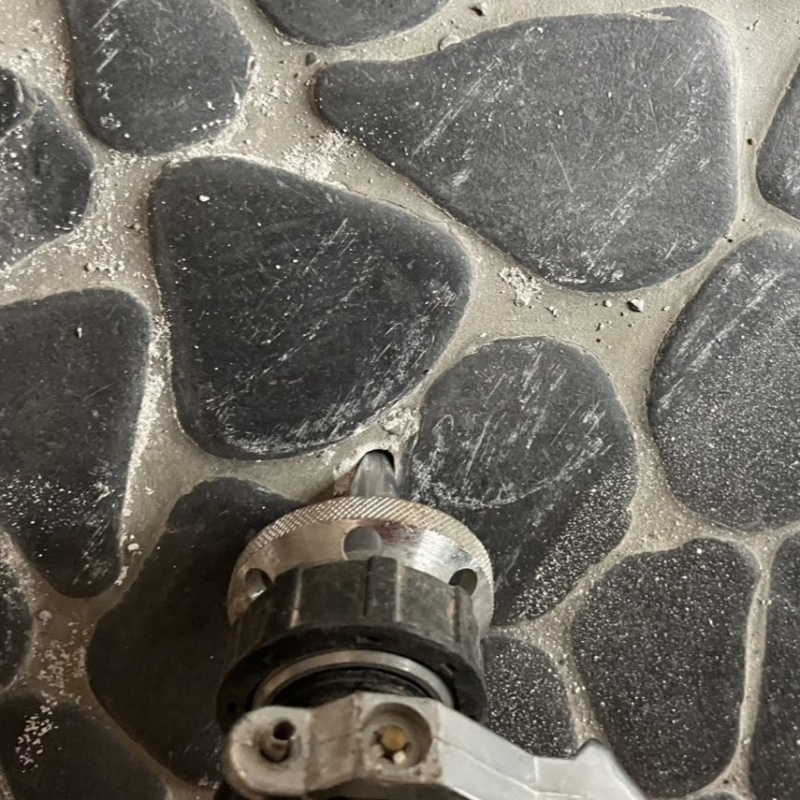 玄関の床にシロアリ駆除剤を注入する様子