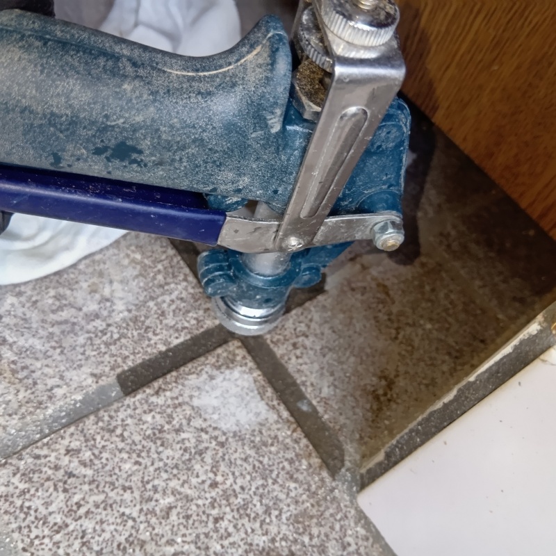 玄関の床にシロアリ駆除剤を注入する様子