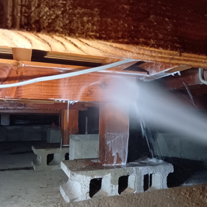 床下の木材にシロアリ駆除剤を散布する様子