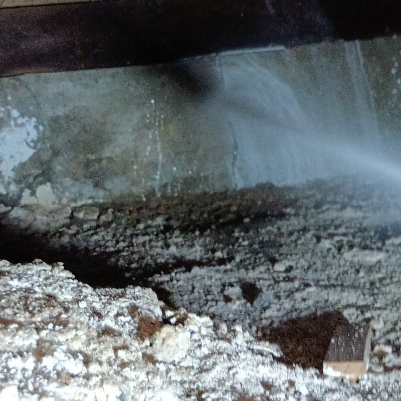 床下の基礎部分にシロアリ駆除剤を散布する様子