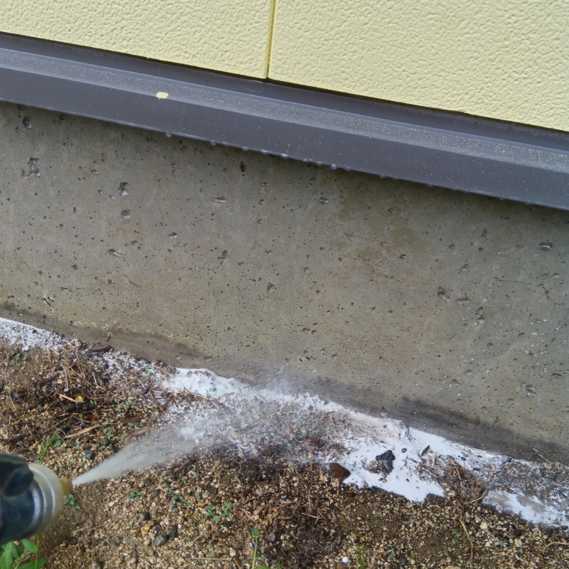 屋外の地面にシロアリ駆除剤を散布