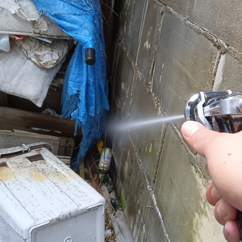 屋外の地面にシロアリ駆除剤を散布