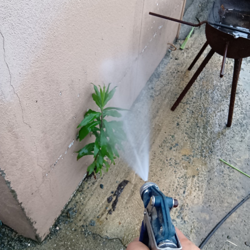 建物外周の土壌にシロアリ駆除剤を吹き付ける様子