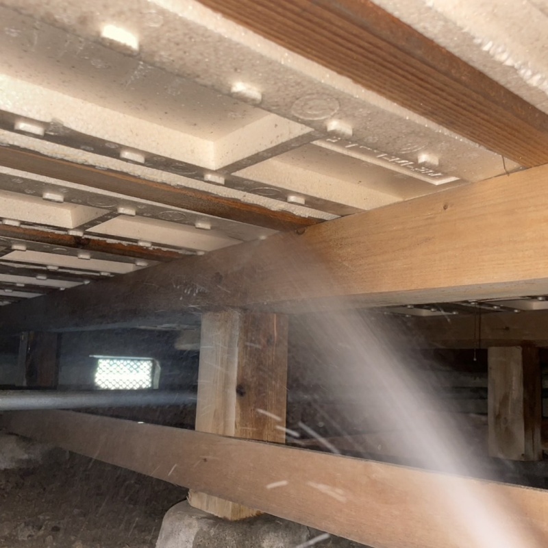 床下の木材に防蟻剤を散布する様子