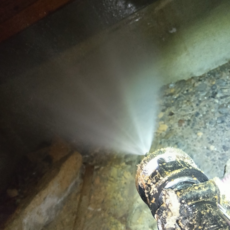 床下の基礎部分にシロアリ駆除剤を散布する様子