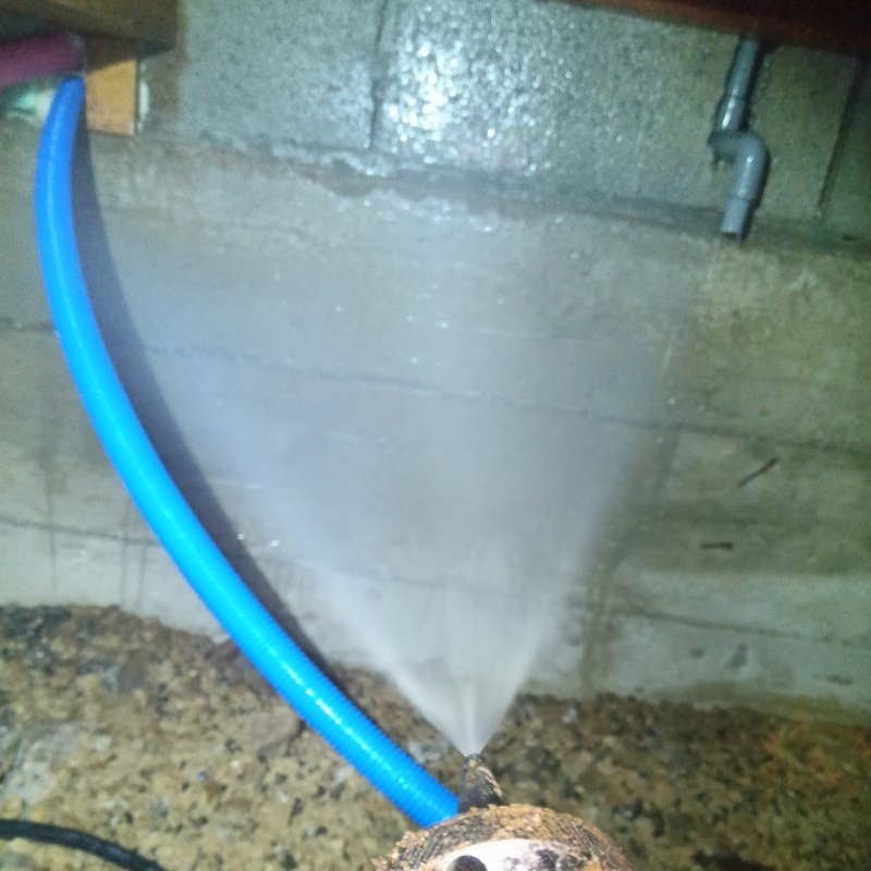 床下の基礎部分にシロアリ駆除剤を散布する様子