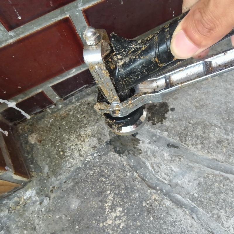 玄関の床にシロアリ駆除剤を注入する様子