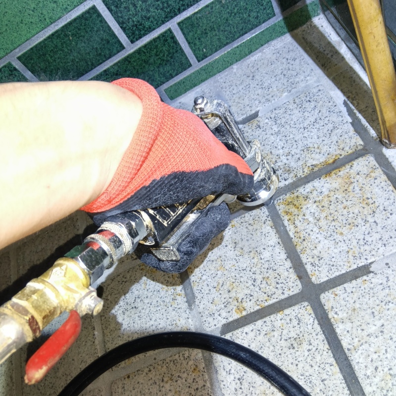 玄関の床にシロアリ駆除剤を注入する様子